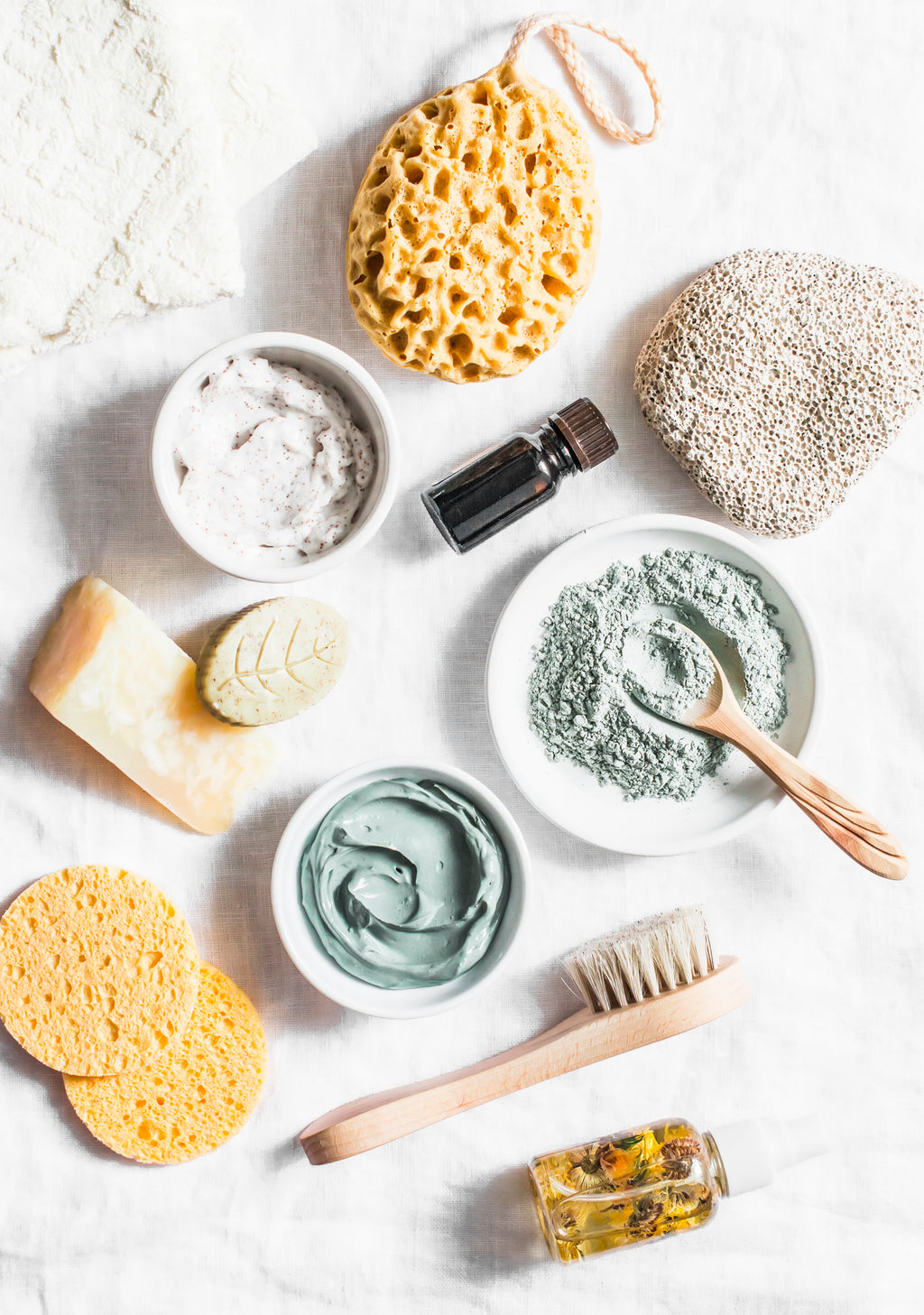 SEO: Spa accessories - nut scrub, sponge, facial brush, natural soap, clay face mask, pumice stone, essential oil on a light background, top view. Healthy lifestyle concept. Beauty, skin care. flat lay stock photo Beauty, Make-Up, Clean, Spa, Skin Care